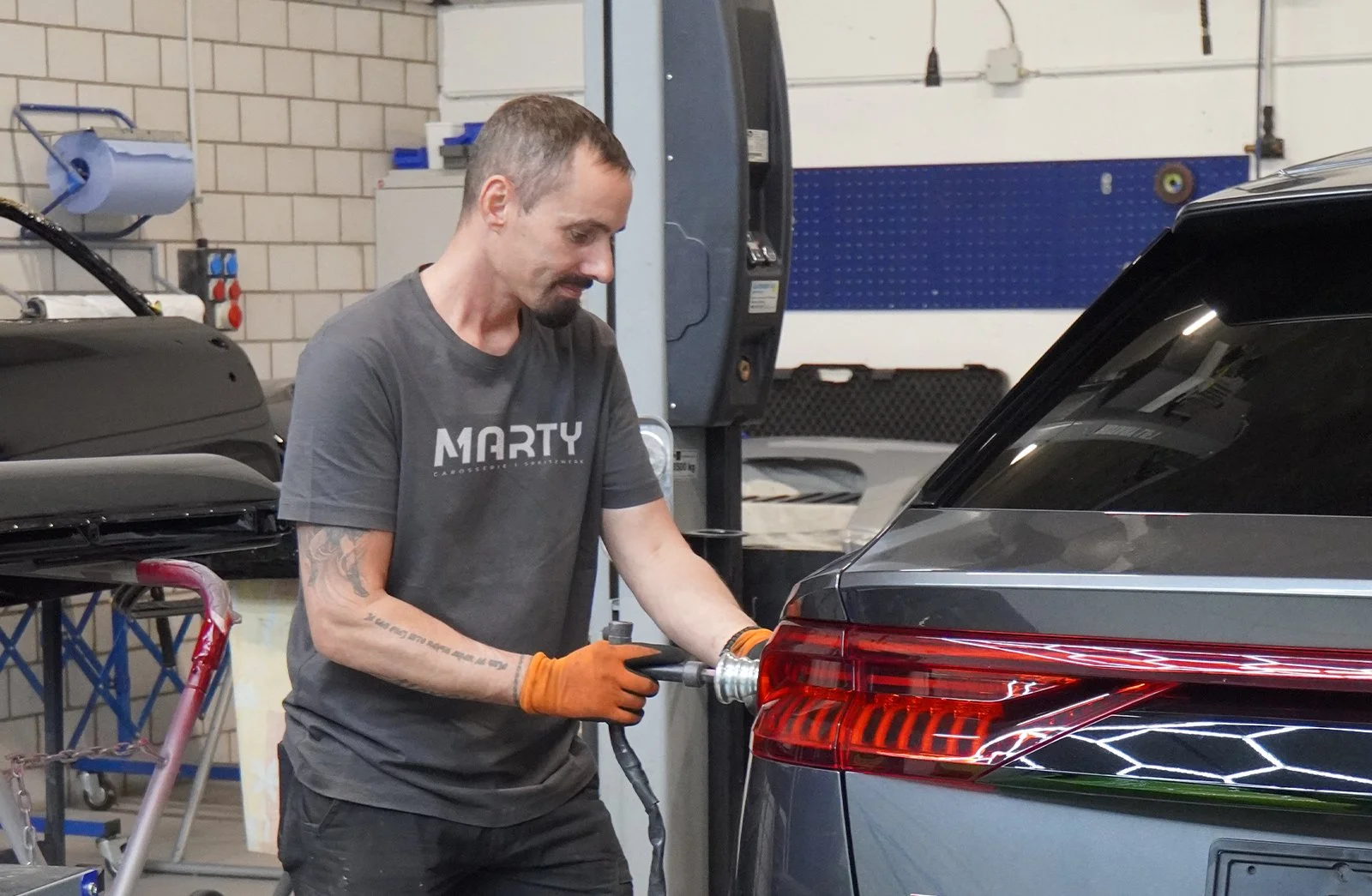 Professionelle Dellenentfernung ohne Lackierung bei Carrosserie Spritzwerk Marty Wangen SZ – Spezialist führt PDR-Reparatur am Fahrzeug durch